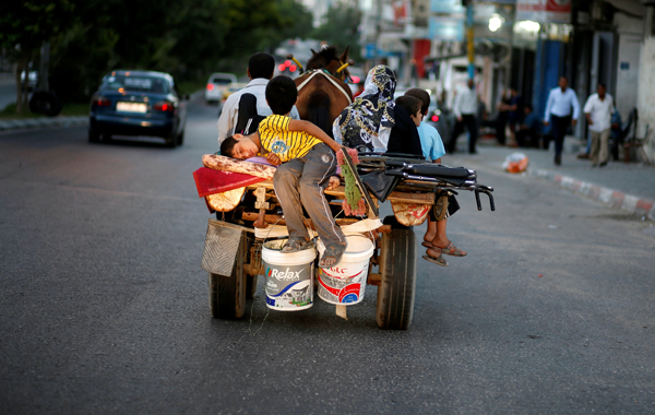 A Palestinian boy sleeps as he rides a horse-drawn cart with his family on a street in Gaza City on Friday (Reuters photo)